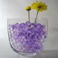 Load image into Gallery viewer, Marbled Vein Water Beads in a glass vase with yellow flowers for decorative purposes.