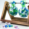 Load image into Gallery viewer, Mixed blue, white, and turquoise decorative water gel beads in a glass vase, perfect for ocean-themed event centerpieces.
