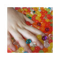 Load image into Gallery viewer, Cosmo Beads Multi-Color Water Beads surrounded by a hand, showcasing their vibrant colors and glossy finish.
