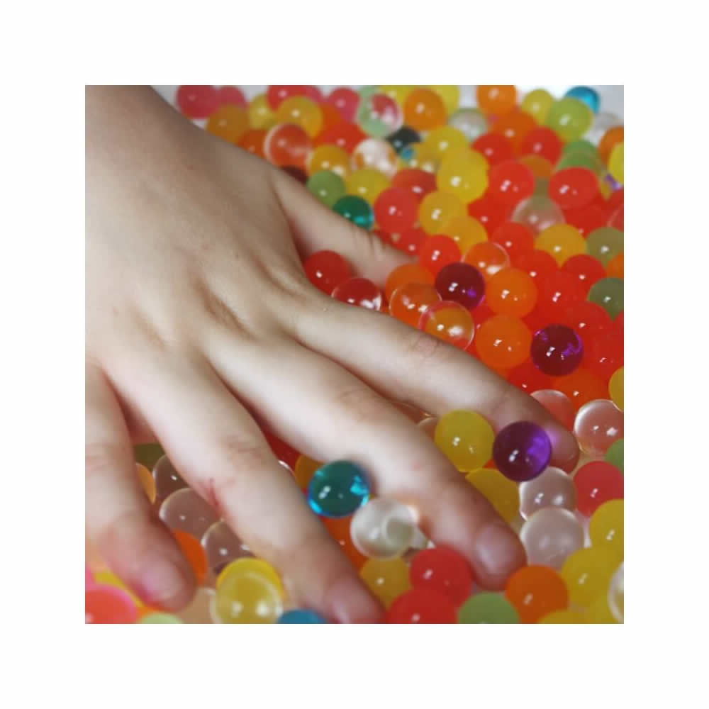 Cosmo Beads Multi-Color Water Beads surrounded by a hand, showcasing their vibrant colors and glossy finish.