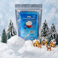 Load image into Gallery viewer, Instant snow powder package displayed with mini Christmas trees and holiday decor
