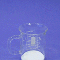 Load image into Gallery viewer, Artificial fake snow rapidly expanding and overflowing from a clear glass mug
