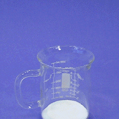 Artificial fake snow rapidly expanding and overflowing from a clear glass mug
