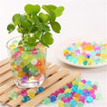 Load image into Gallery viewer, Cosmo Beads Multi-Color Water Beads displayed in a glass with greenery and colorful beads on a wooden surface.
